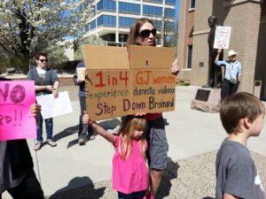 A woman attends the rally at Grand Junction City Hall to protest Richard Brainard taking office. Brainard has admitted he struck his live-in girlfriend to get her to "shut her mouth."