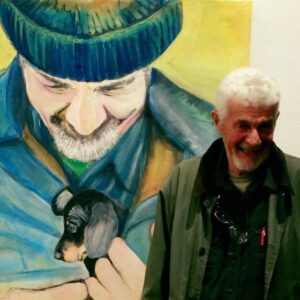 Mel in front of an original painting of him with a puppy, by his wife, art teacher Vera Mulder